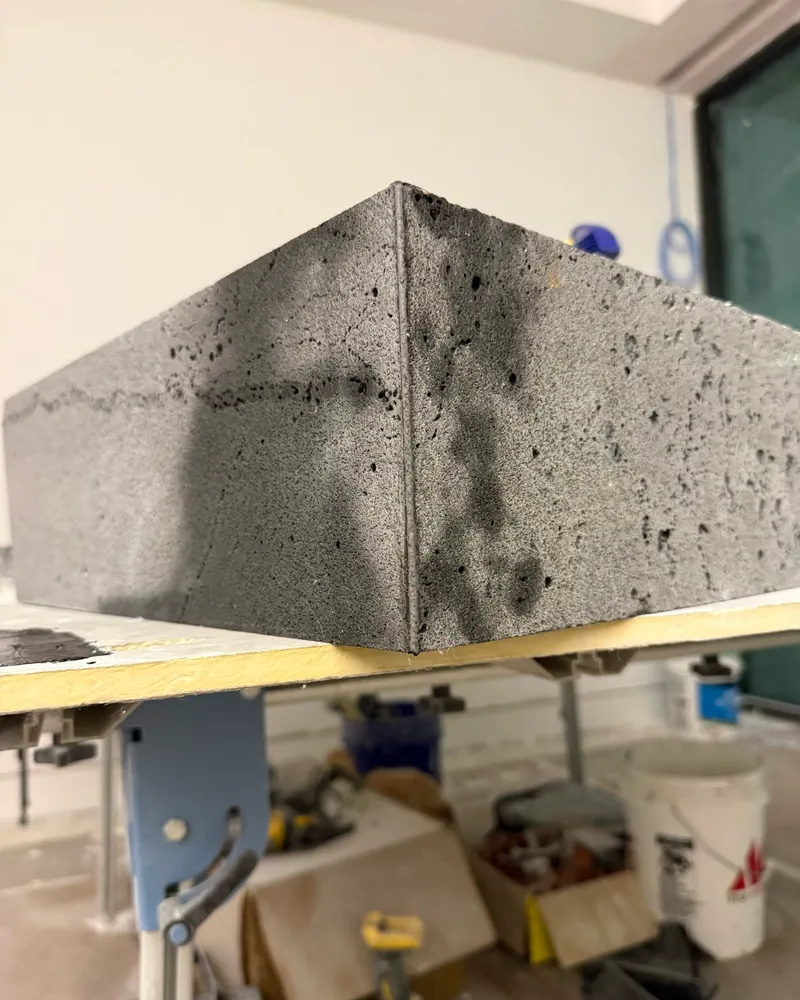 Lava stone epoxy miter with micro holes recreated in the seam, by Floors of Glory